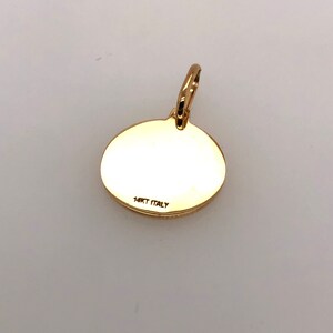 Pode incluir: Um pingente dourado com um design circular. Possui uma argola na parte superior para uma corrente. O texto "14KT ITALY" est&aacute; estampado na parte de tr&aacute;s. O pingente &eacute; provavelmente feito de ouro e &eacute; uma joia. Medidas em cm.