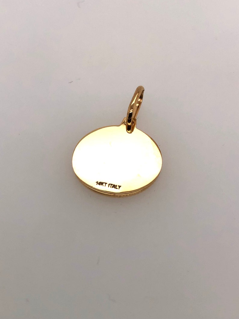 Pode incluir: Um pingente dourado com um design circular. Possui uma argola na parte superior para uma corrente. O texto "14KT ITALY" est&aacute; estampado na parte de tr&aacute;s. O pingente &eacute; provavelmente feito de ouro e &eacute; uma joia. Medidas em cm.