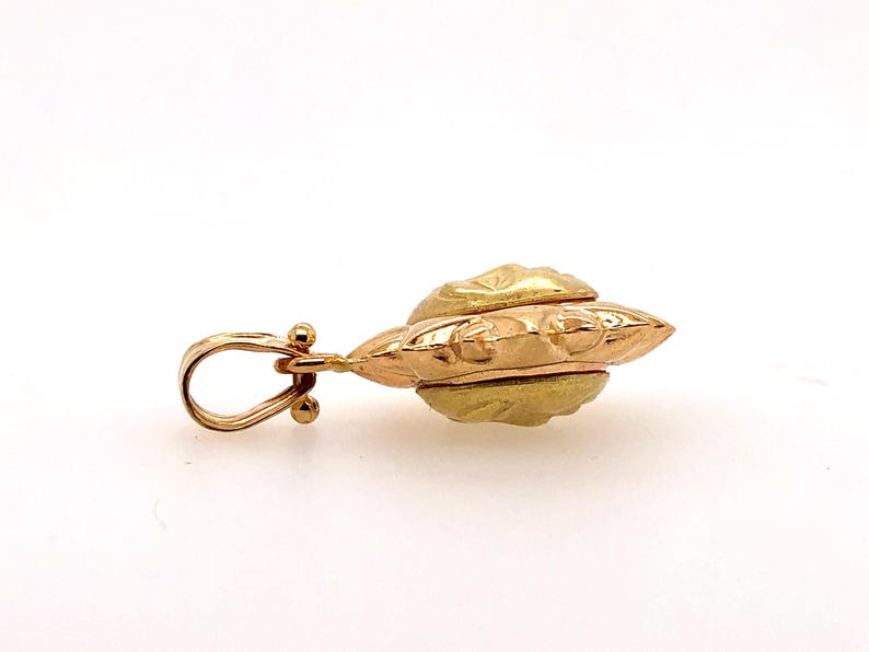 May include: A gold pendant with a detailed, ornate design. The pendant has a loop for attaching to a chain.