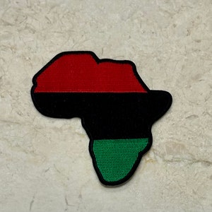 May include: An embroidered patch shaped like the continent of Africa. The patch is red, black, and green, representing the Pan-African flag.