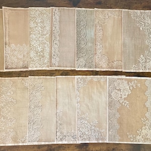 May include: A collection of vintage-style, rectangular fabric pieces with intricate white lace borders and floral designs. The pieces have a beige and tan color palette, with variations in the lace patterns. The arrangement suggests a set of decorative textiles.