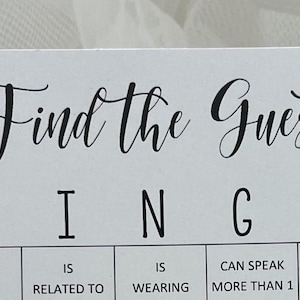 May include: A white card with black text that reads "Find the Guest Bingo". The card has a grid with the letters B, I, N, G, and O at the top. Each square has a different prompt, such as "Is Left", "Is Related To", "Is Wearing", "Can Speak More Than 1 Language", and "Traveled 1 Hour+ To Get Here".