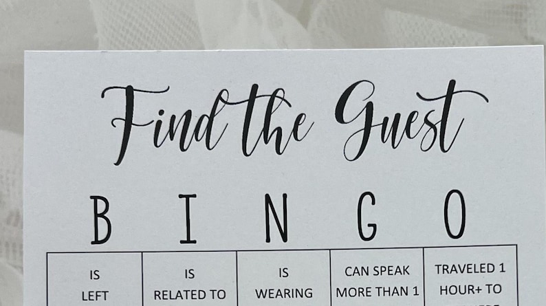 May include: A white card with black text that reads "Find the Guest Bingo". The card has a grid with the letters B, I, N, G, and O at the top. Each square has a different prompt, such as "Is Left", "Is Related To", "Is Wearing", "Can Speak More Than 1 Language", and "Traveled 1 Hour+ To Get Here".
