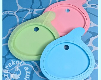 May include: Three circular silicone lids with a small tab and a central hole, colored in light blue, light green, and light pink. Each lid features a raised outer rim and a smooth, flat surface. The text azurekoi is visible in the corner.