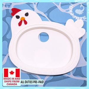 May include: A white chicken-shaped cookie cutter with a red glittery comb, black glittery eyes, and an orange beak. The cutter features a central circular cutout and a raised white frame. The design includes a small tail section on the right side.