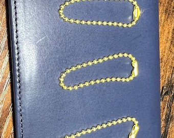 May include: Three gold-colored ball chain keychains on a blue background. Each keychain is about 2 inches long.