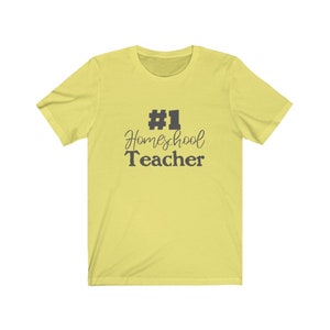 K&ouml;nnte beinhalten: Ein gelbes T-Shirt mit kurzen &Auml;rmeln und dem Text "#1 Homeschool Teacher" in Schwarz.