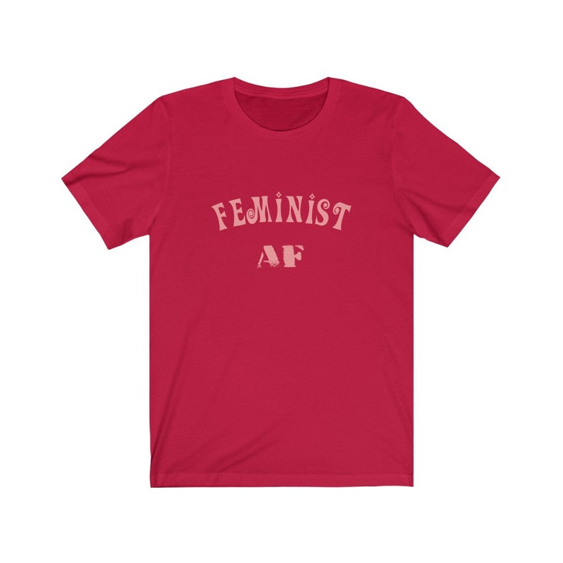 Op de afbeelding: Rood T-shirt met korte mouwen met de tekst "FEMINIST AF" in roze letters.