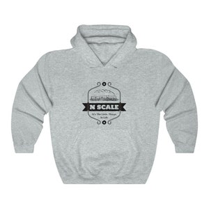 Puede incluir: Una sudadera con capucha gris con un gr&aacute;fico en blanco y negro de un tren con el texto "N SCALE It's The Little Things In Life"