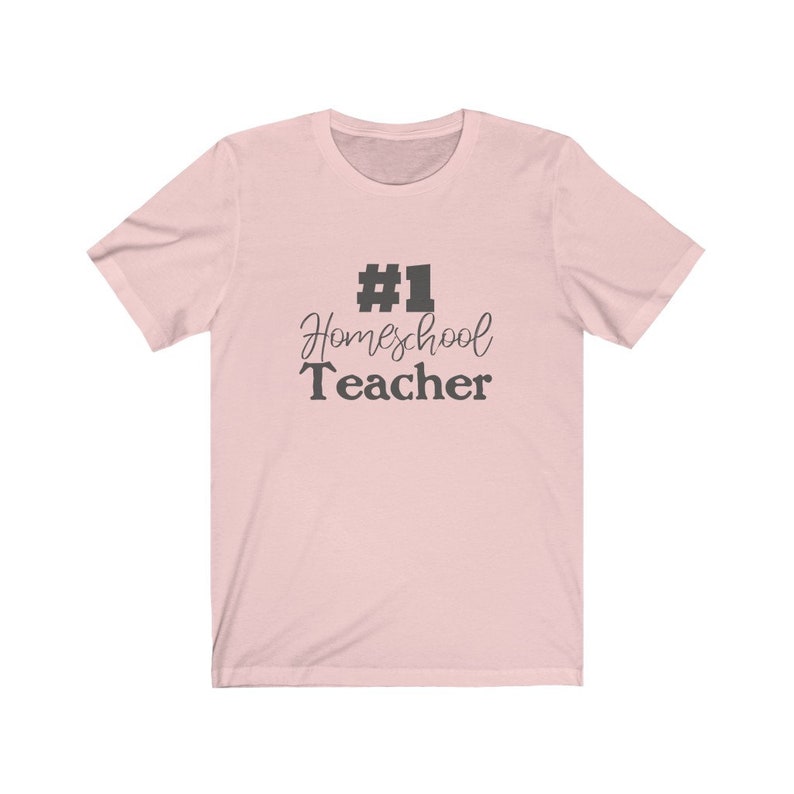K&ouml;nnte beinhalten: Ein rosa T-Shirt mit dem Text "#1 Homeschool Teacher" in Schwarz.