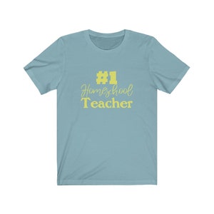 K&ouml;nnte beinhalten: Ein hellblaues T-Shirt mit dem Text "#1 Homeschool Teacher" in Gelb.