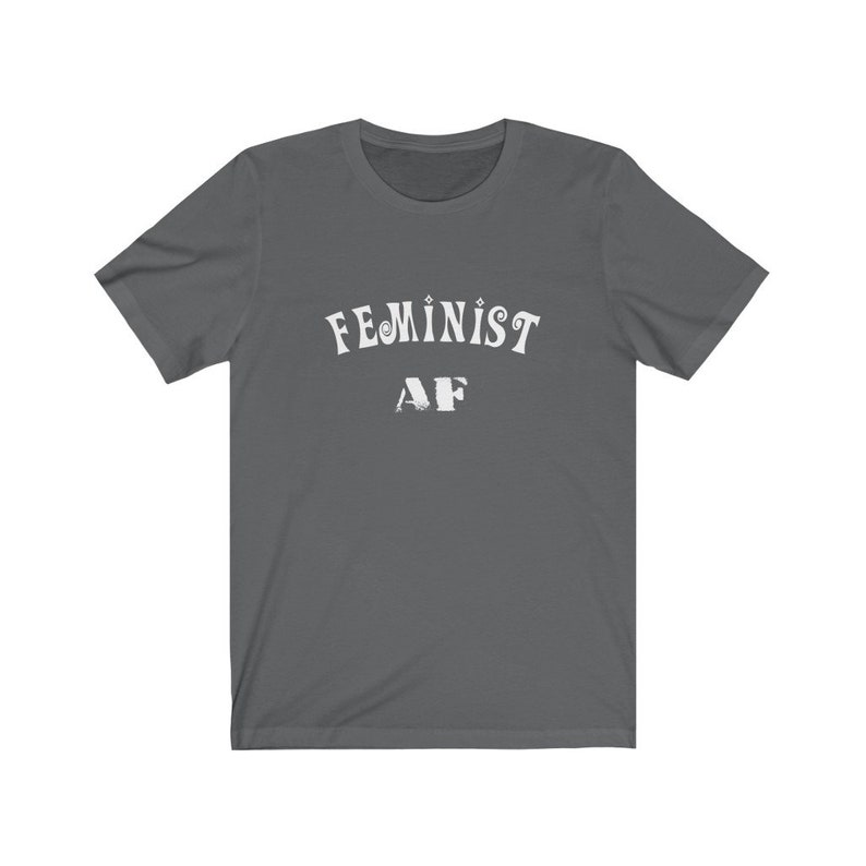Op de afbeelding: Een donkergrijs T-shirt met de tekst "FEMINIST AF" in wit.