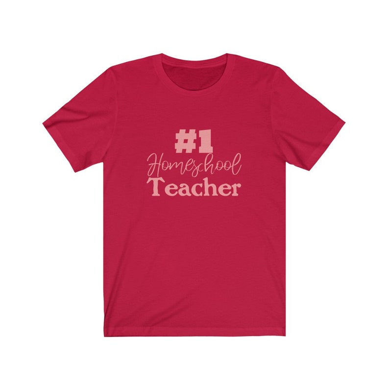 K&ouml;nnte beinhalten: Rotes T-Shirt mit kurzen &Auml;rmeln und dem Text "#1 Homeschool Teacher" in Rosa.
