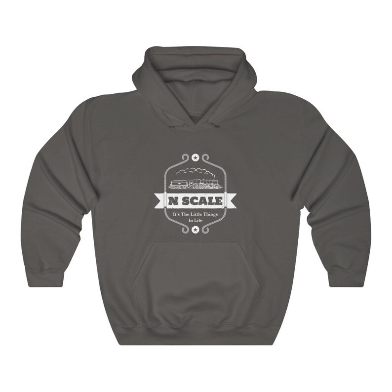Puede incluir: Una sudadera con capucha gris oscuro con un dise&ntilde;o gr&aacute;fico blanco de un tren y el texto "N SCALE It's The Little Things In Life".