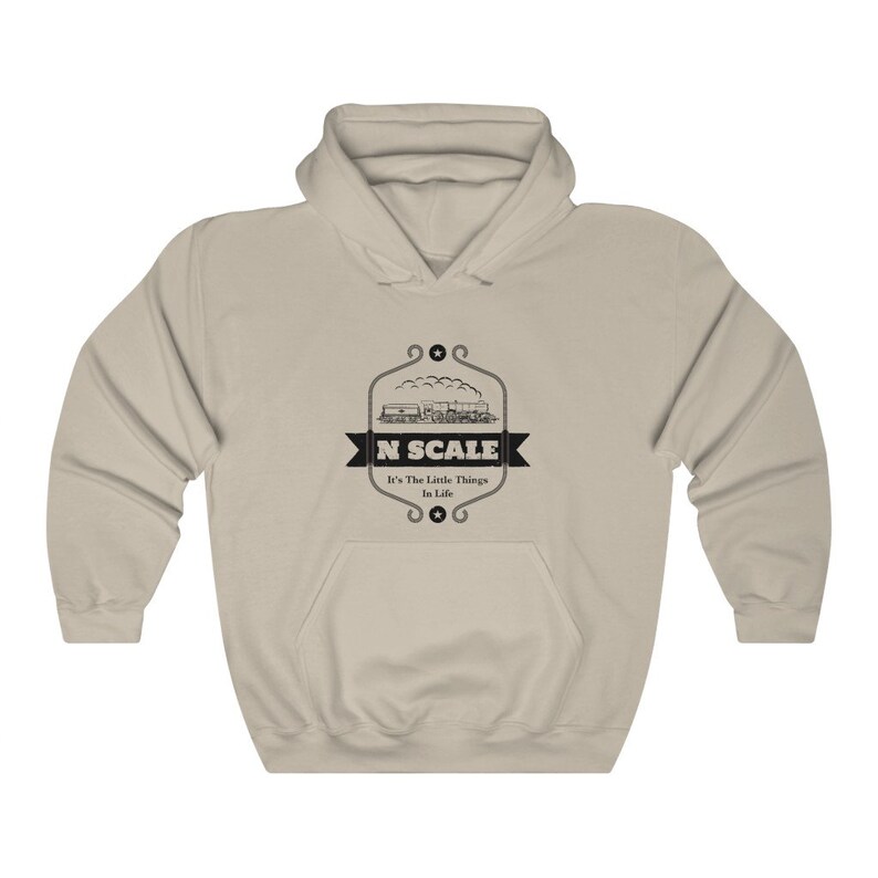 Puede incluir: Una sudadera con capucha de color beige con un gr&aacute;fico negro de un tren y el texto "N SCALE It's The Little Things In Life".
