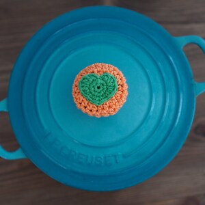 May include: A blue enameled cast iron pot with a crocheted heart-shaped lid knob.