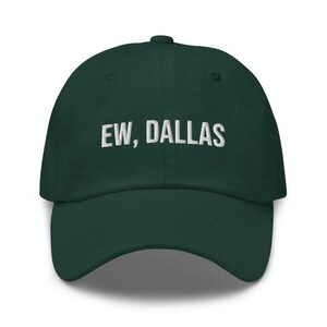May include: A dark green baseball cap with white embroidered text that reads "EW, DALLAS".