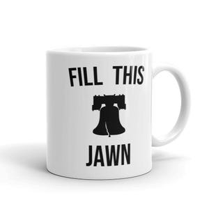 Puede incluir: Taza de cer&aacute;mica blanca con una silueta negra de la Campana de la Libertad y el texto "FILL THIS JAWN".