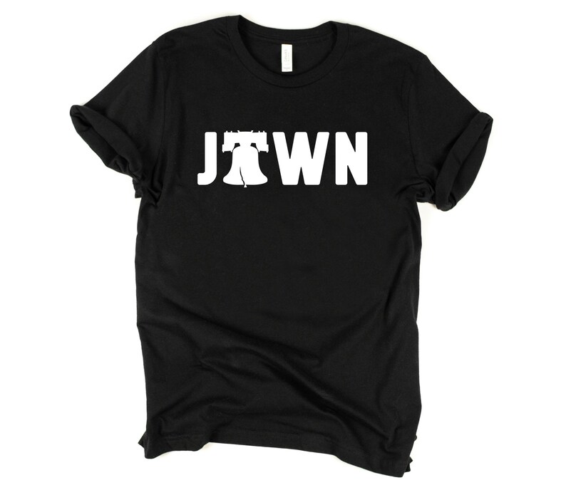 Peut inclure: T-shirt noir avec un graphique blanc de la Liberty Bell et le mot "JTOWN" imprim&eacute; sur le devant.