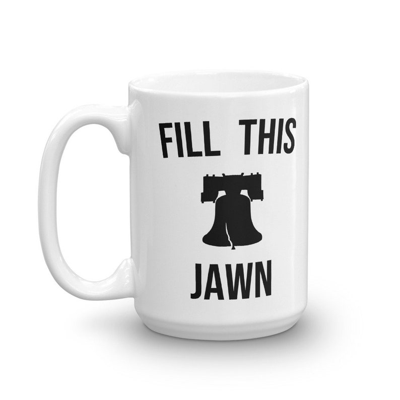 Puede incluir: Taza de cer&aacute;mica blanca con una silueta negra de la Campana de la Libertad y el texto "FILL THIS JAWN".