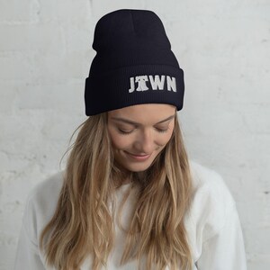 May include: Black beanie with a white "JTOWN" graphic. The graphic includes a stylized silhouette of a Liberty Bell.