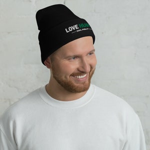 K&ouml;nnte beinhalten: Eine schwarze M&uuml;tze mit einem wei&szlig;en und gr&uuml;nen gestickten Logo, auf dem "LOVE HURTS - XOXO, PHILLY" steht.
