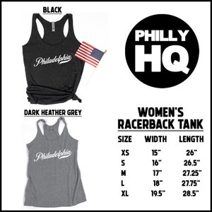 May include: Dark heather grey and black racerback tank tops with the word "Philadelphia" in white script. The image includes a small American flag and a black circle with "PHILLY HQ" in white. Size chart included.