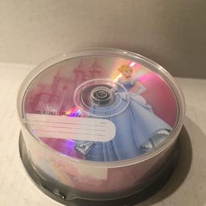 May include: A clear DVD case with a pink and white design featuring Cinderella in a blue gown. The DVD is labeled "Disney" and has a title card that says "TITLE".