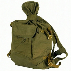 May include: Olive green canvas backpack with a drawstring closure and a flap pocket. The backpack features adjustable shoulder straps and metal buckles. The top of the backpack has a unique knotted design.