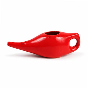 Puede incluir: Una vibrante olla neti de cer&aacute;mica roja, dise&ntilde;ada para la irrigaci&oacute;n nasal. La olla presenta un pico largo y curvo, un asa redondeada y una amplia abertura. El acabado brillante y la forma &uacute;nica la convierten en un art&iacute;culo de bienestar distintivo.