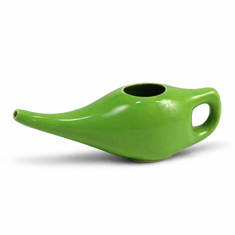Puede incluir: Una olla neti de cer&aacute;mica verde brillante con un pico curvo, una abertura redonda y un asa. La olla est&aacute; dise&ntilde;ada para la irrigaci&oacute;n nasal y tiene un acabado liso y brillante. El dise&ntilde;o recuerda a una l&aacute;mpara de genio.