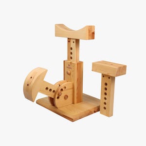 May include: Wooden toy with a saddle, a lever, and a platform. The toy is made of natural wood and has a light brown color.