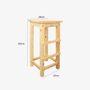 May include: A natural wood step stool, 31.5 inches tall, 14.6 inches wide, and 14.9 inches deep. The stool has a square top and three horizontal rungs for support. The wood has visible grain and is unfinished.