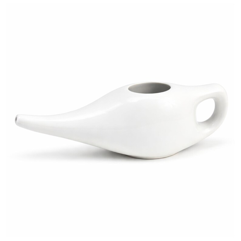 Puede incluir: Una olla neti de cer&aacute;mica blanca con un pico largo y un asa. La olla tiene un cuerpo redondeado y una amplia abertura en la parte superior. El dise&ntilde;o es simple y funcional, adecuado para la irrigaci&oacute;n nasal.