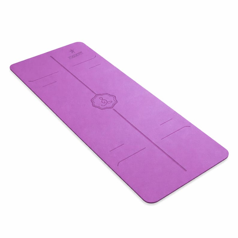 May include: A lavender yoga mat with a textured surface. The mat has alignment lines and a central design with a musical note symbol. The brand name is printed at the top. The mat is rectangular and designed for exercise.