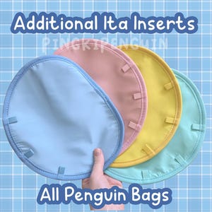 May include: Four round ita inserts in blue, light blue, yellow, and pink. The inserts are made of fabric and have a sewn edge. The inserts are arranged in a stack with the blue insert on the bottom and the pink insert on the top. The text "Additional Ita Inserts" is at the top of the image and the text "All Penguin Bags" is at the bottom of the image.