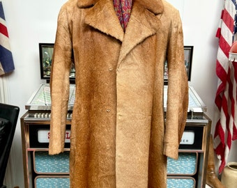 May include: A long, brown fur coat with a large collar. The coat is buttoned up the front and has a simple design.