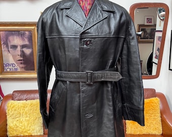 Chaqueta/gabardina de cuero grueso negro con cinturón y 3 botones, estilo dandy Mod de Philmar Clad, de finales de los 60 y principios de los 70. Tallas: Grande a XL. Excelente calidad.