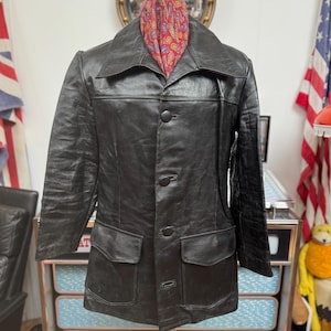 vintage des années 1970 possédait-il une peau de vache noire épaisse plus tôt ? Blouson en cuir avec col italien fabuleux et boutons en cuir. Cuir de qualité. Grand 42-43 pouces