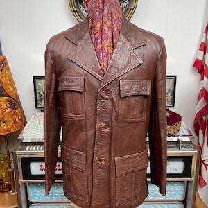 Vintage late 1960s early 70’s thick brown leather 4 pocket spread collar Safari sport’s leisure jacket,Slight wear in places.Large 42-44 vgc