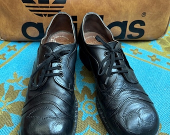 Zapatos Frank Wright de cuero negro con punta de pato y cuchara, estilo subcultura, de los años 70 y con ligero tacón de plataforma. Estilo soul norteño con suela de ante. Talla 8.5