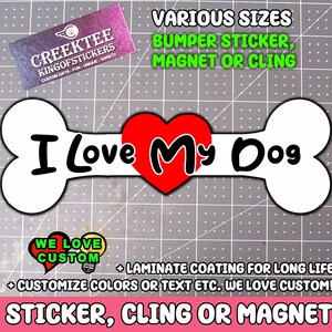 Könnte beinhalten: Ein weißer, knochenförmiger Aufkleber mit dem Text "I Love My Dog" und einem roten Herz. Der Aufkleber enthält auch den Text "Bumper Sticker, Magnet or Cling" und "Sticker, Cling or Magnet".