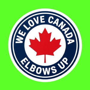 Puede incluir: Una pegatina circular con un borde azul oscuro que presenta el texto blanco WE LOVE CANADA en la parte superior y ELBOWS UP en la inferior. En el centro, una hoja de arce roja destaca sobre un fondo blanco, todo sobre un campo verde brillante.