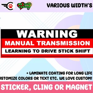 Op de afbeelding: Rode en zwarte waarschuwings sticker met de tekst "WARNING MANUAL TRANSMISSION LEARNING TO DRIVE STICK SHIFT". De sticker bevat ook de tekst "WE LOVE CUSTOM!" en "STICKER, CLING OR MAGNET".