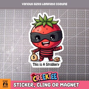 May include: A red cartoon strawberry wearing a black eye mask and striped shirt, holding a bag of money. The text "This is A Strobbery" is below the image. The image is for a sticker, cling or magnet.