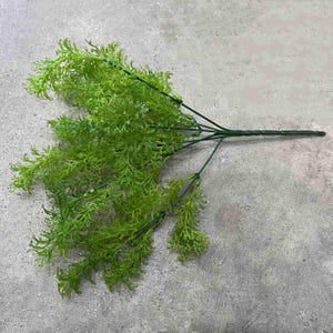May include: A bunch of artificial green ferns with wire stems. The ferns are arranged in a cluster and have a natural, realistic look.