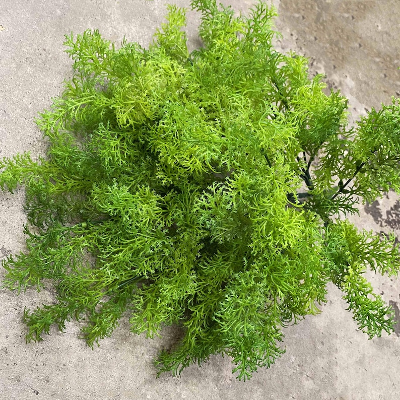 May include: A bunch of artificial green fern sprigs. The sprigs are long and feathery, with a realistic texture.