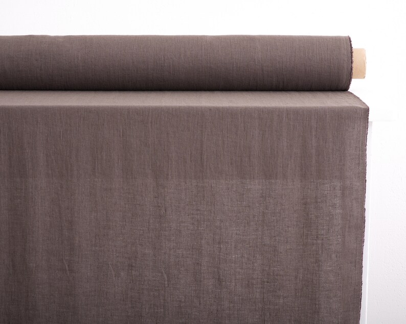 May include: A roll of brown linen fabric. The fabric is woven with a subtle texture and has a natural, earthy tone.