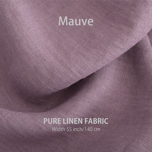 May include: Mauve coloured pure linen fabric. The fabric is folded and has a soft, textured appearance. The fabric is 55 inches wide or 140 cm.