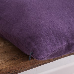 Close up of a deocorative square pillow cover, in the color dark violet showcasing the hidden zipper closure.